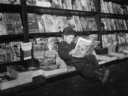 Boy reading "Captain America" (March 1942 issue) at a magazine stand