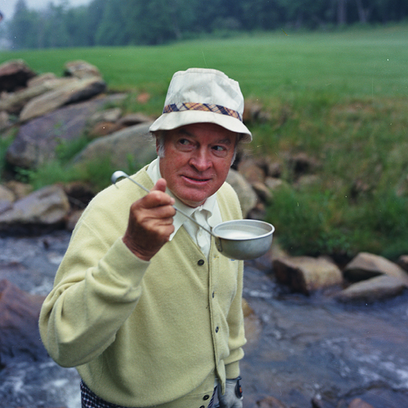 Bob Hope drinking water from dipper on golf course