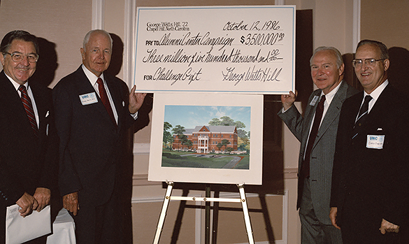 UNC President Bill Friday, George Watts Hill, Ralph Strayhorn, and UNC Chapel Hill Chancellor Christopher Fordham posed with Hill's presentation check dated October 12, 1986 and an artist's rendering of the alumni center building. (Photograph cropped by blog editor.)