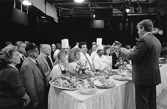 Governor Jim Martin addressing a crowd of food workers and celebrities including Charlie Justice, Phil Ford, Clyde King, and William Friday. Taken at a North Carolina tourism event coordinated by Hugh Morton, Jr. to address the effects of "red tide" algae.