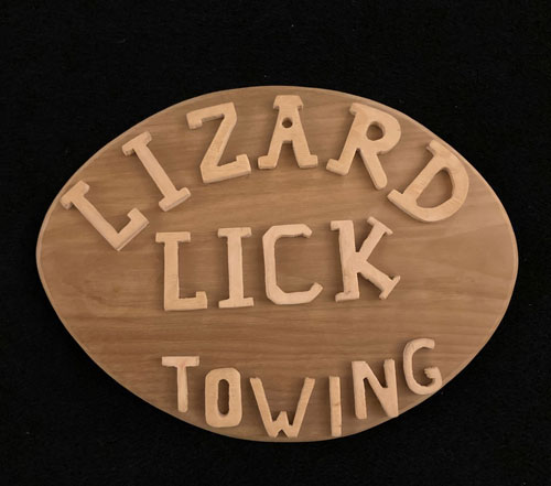 Football shaped plaque with the embossed words, "Lizard Lick Towing."
