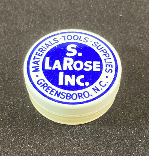 Watch parts tin with the words "S. LaRose Inc." in the center of the cover. The words "Materials, Tools, Supplies, Greensboro, N.C." circle around the name of the company.
