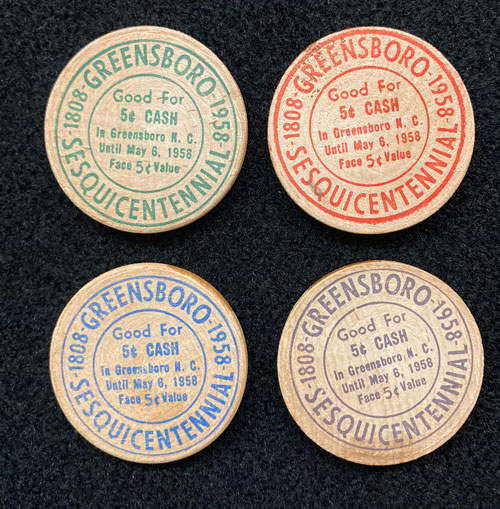 Verso of wooden nickels with words Greensboro Sesquicentennial.