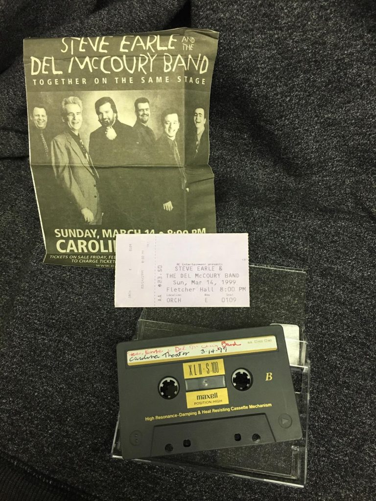 Photo of a cassette tape next to its case. Also includes ticket stub that reads "Steve Earle and the Del McCoury Band live show at the Carolina Theatre in Durham, NC." Flyer with black and white picture of Steve Earle and Del McCoury Band. 