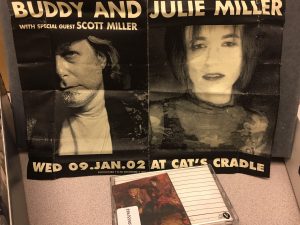 Tape on a table, also next to a black and white flyer for Buddy and Julie Miller at the Cat's Cradle. Flyer has photo of Buddy and Julie Miller. 