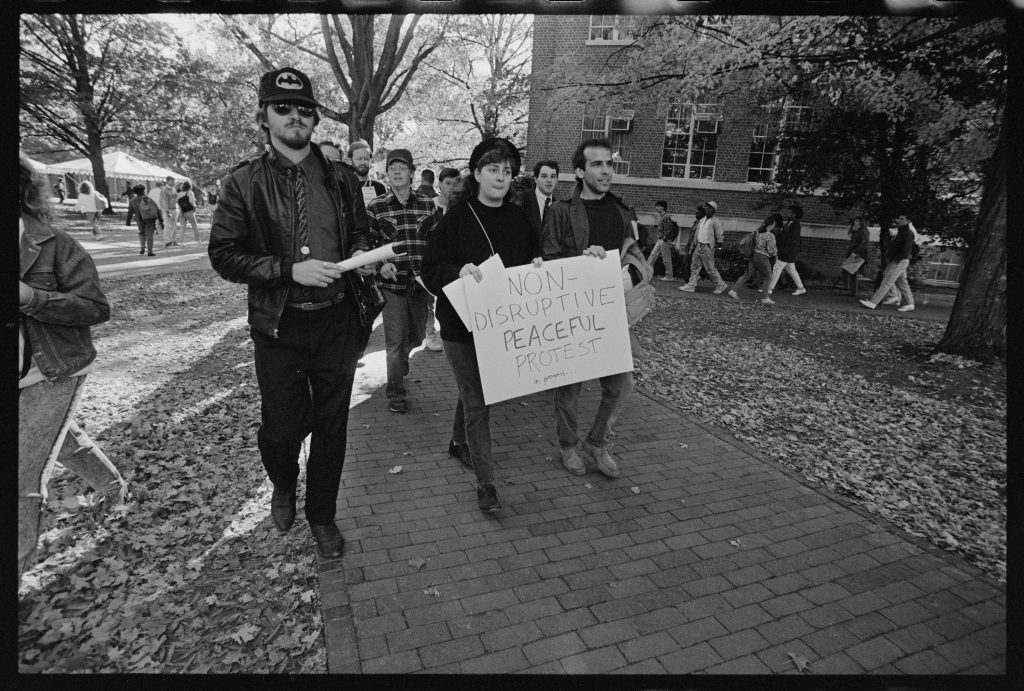 Students march to Hanes Hall holding a sign stating, "Non-Disruptive Peaceful Protest"