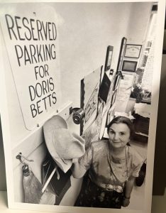 Doris Betts in her office near a sign that reads "Reserved Parking for Doris Betts"