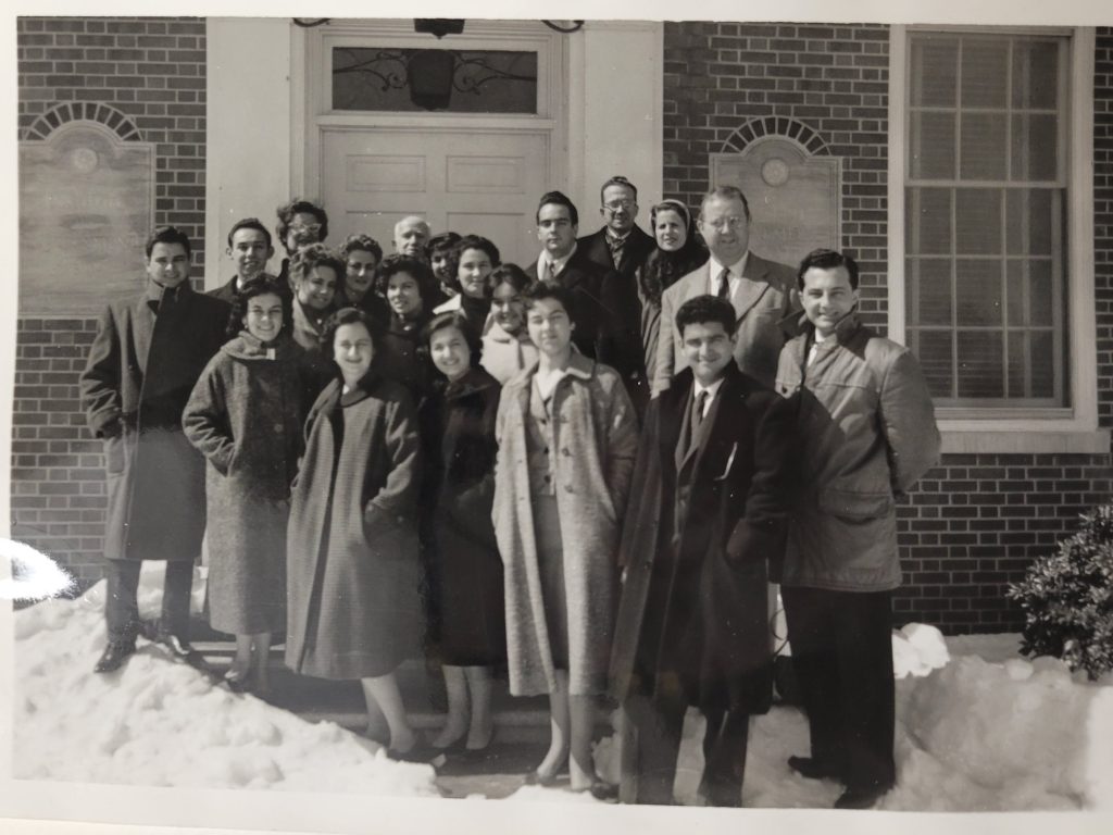 Several male and female students dressed in jackets in the snow.